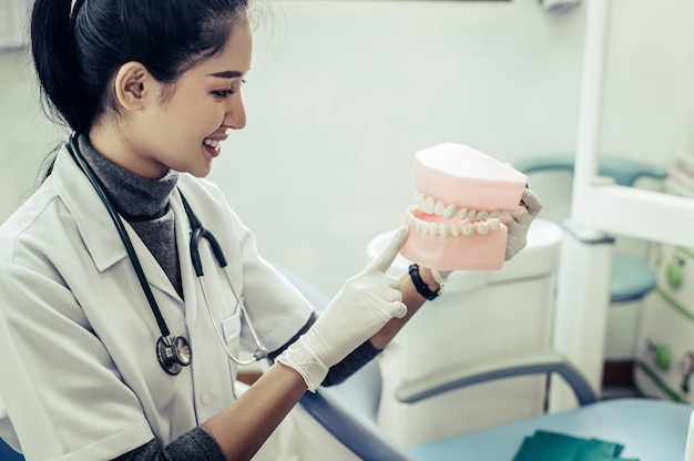 Protésico dental explicando una prótesis a una paciente